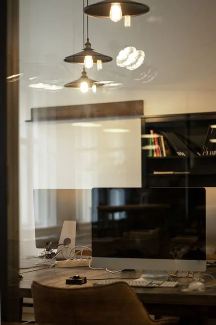 A modern workspace featuring dual computer monitors displaying web design projects, emphasizing technology and productivity.